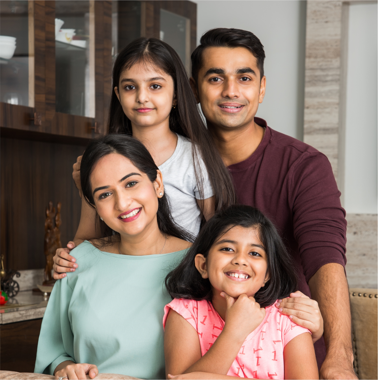 portrait happy indian asian young family while sitting sofa lying floor sitting against wall